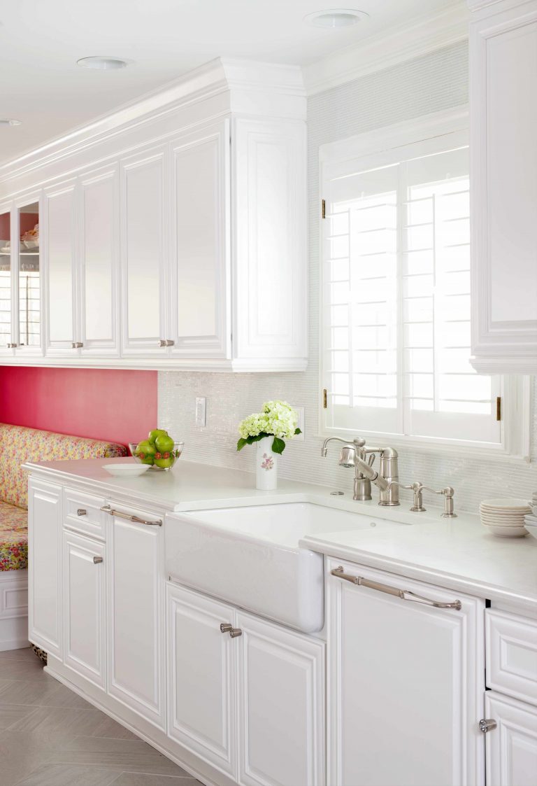 renovated kitchen with white cabinetry and farmhouse sink hot pink wall