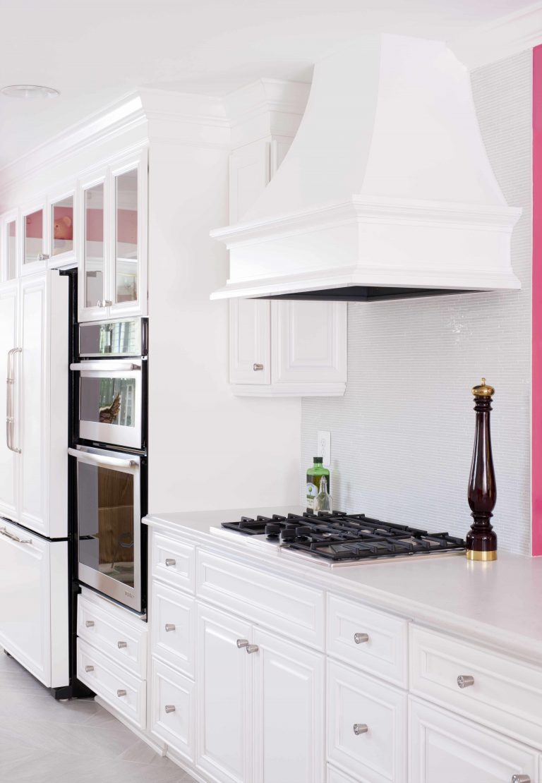 white kitchen with hot pink walls gas stovetop and range hood stainless steel appliances wall oven
