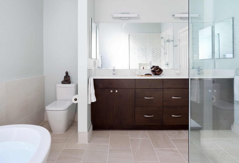 dark wood vanity with double sinks and separate toilet space neutral colors