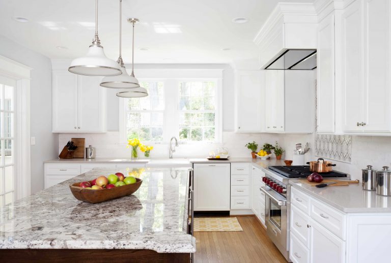 bright kitchen two tone cabinetry wood floors center island with pendant lighting