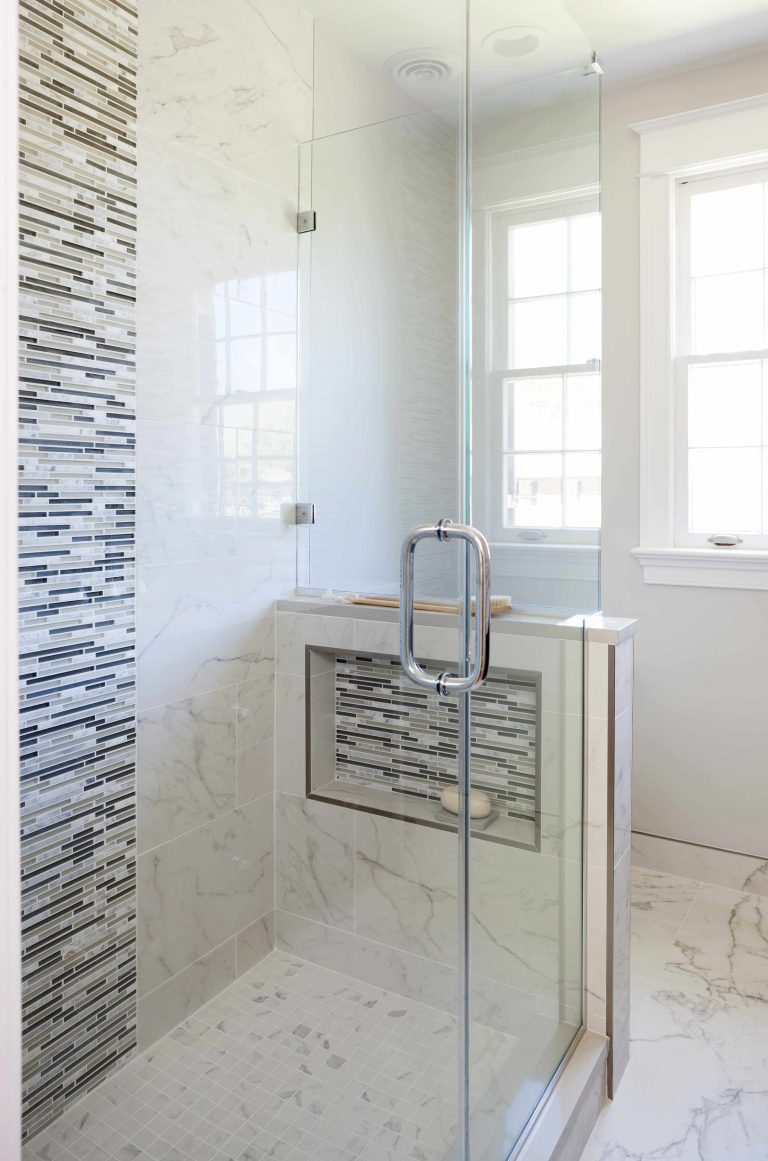 bright bathroom glass shower built in storage nook tile feature wall