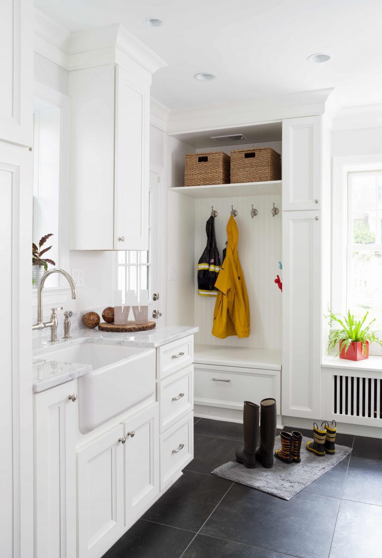 bright white mudroom in Maryland house with built-in cubbies and storage dark wood floors and farmhouse sink nickel hardware