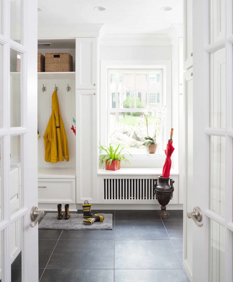bright white mudroom in Maryland house with built-in cubbies and storage dark wood floors