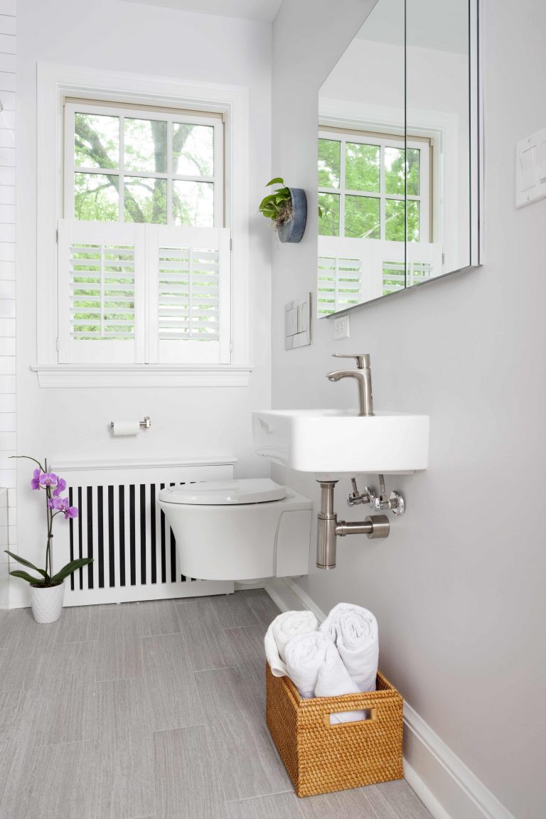 bright white sleek bathroom in dc home floating toilet and sink with exposed pipes
