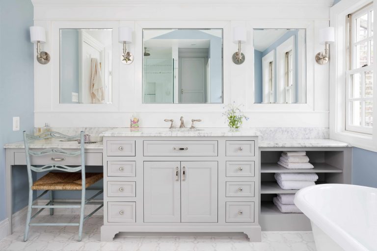 large vanity with sink and built in makeup area gray cabinetry open shelving storage soft neutral color palette sconce lighting