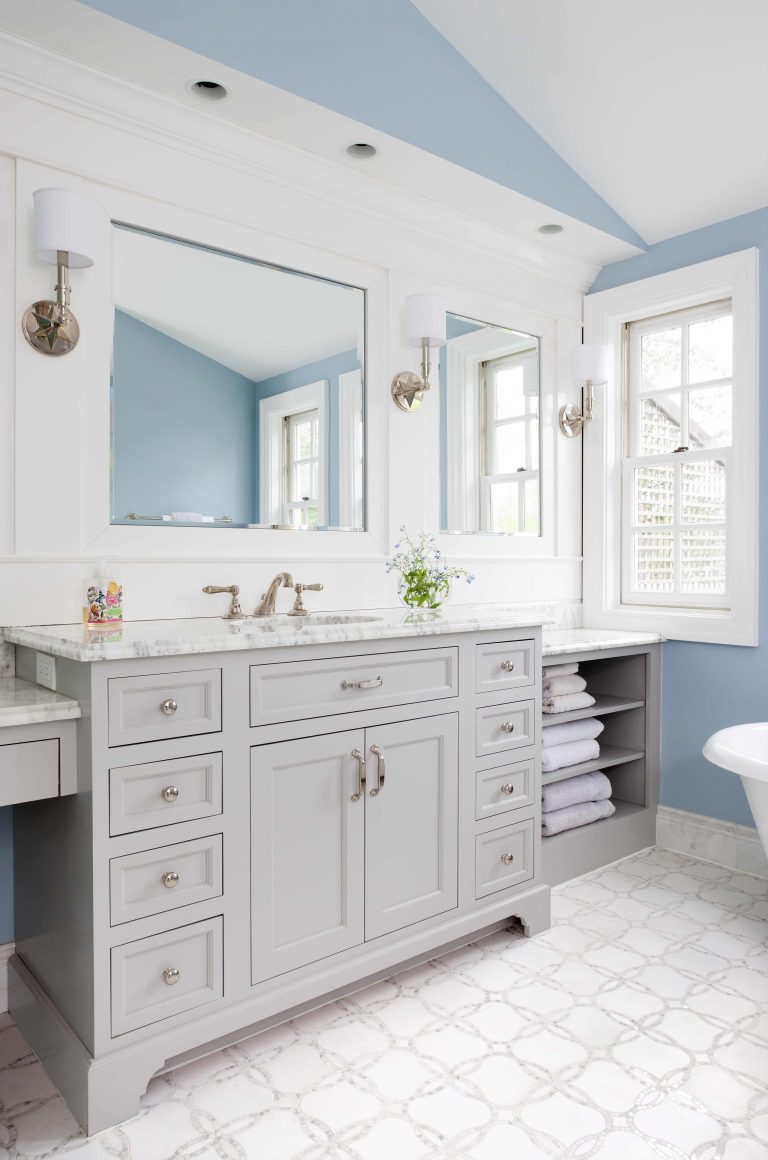 large vanity with sink and built in makeup area gray cabinetry open shelving storage soft neutral color palette sconce lighting