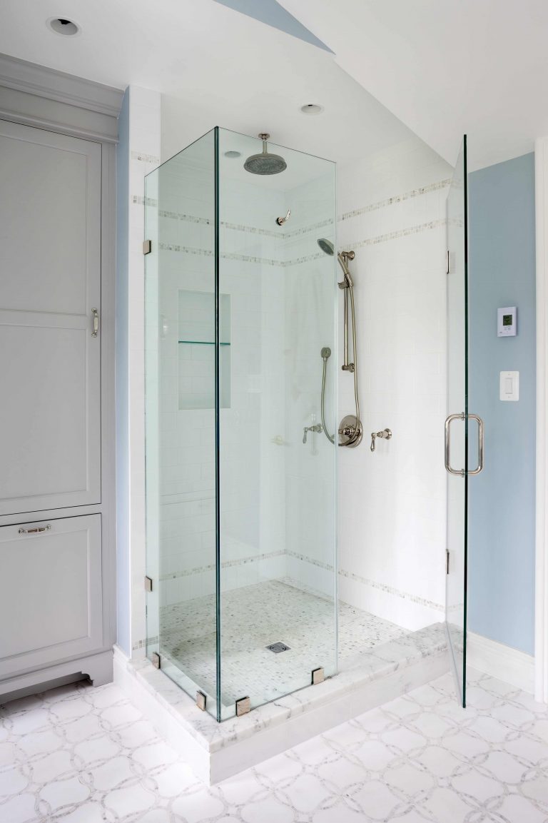 separate shower stall with glass wall and built in storage nook