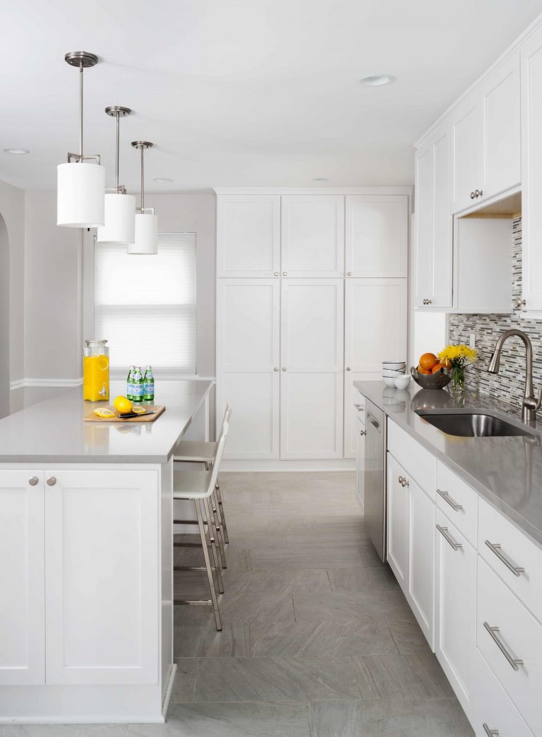modern kitchen white cabinetry gray countertops island with seating and pendant lighting