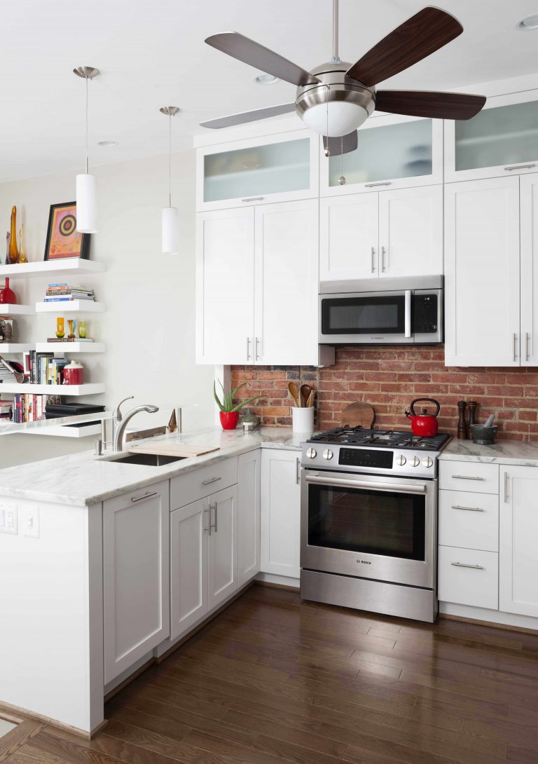 DC kitchen dark hardwood floors white cabinets frosted glass upper cabinets red brick backsplash open to living room