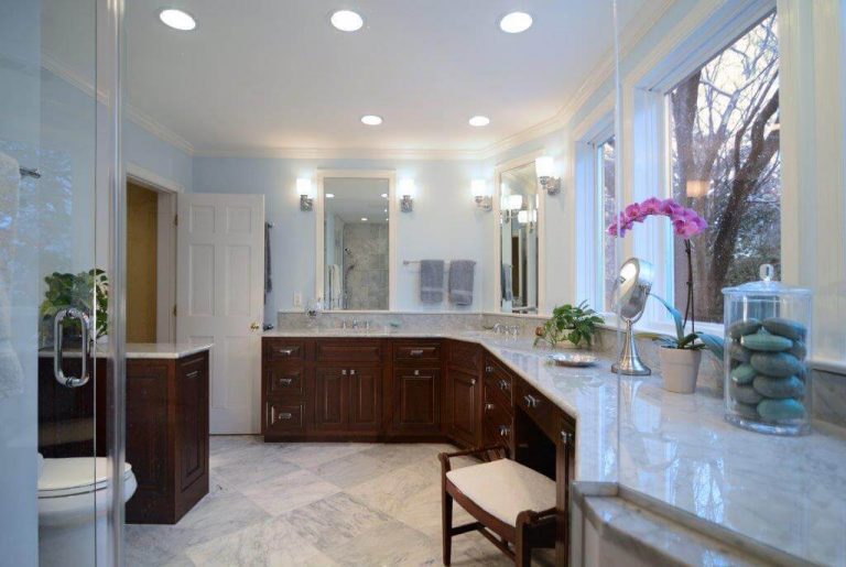 large master bathroom lots of counter space dark wood cabinetry tray ceiling and recessed lighting neutral color palette