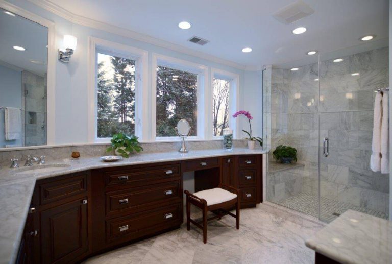 large master bathroom big windows lots of counter space dark wood cabinetry separate shower stall with glass door and built in bench neutral color palette