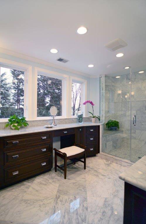 large master bathroom big windows lots of counter space dark wood cabinetry separate shower stall with glass door neutral color palette