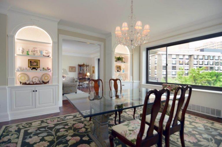 traditional dining room in dc home glass table with antique chairs chandelier and crown molding built in storage and china display large window
