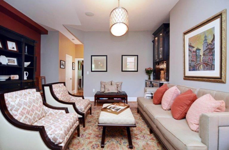 elegant and traditional living area soft blue walls warm color palette hanging overhead lighting built in storage