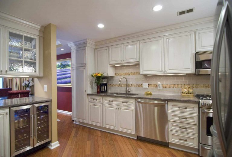 traditional style kitchen in dc home warm color palette white cabinets with glass door uppers wood floors beverage refrigerator stainless steel appliances