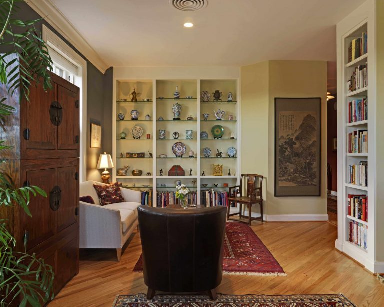 modern living area with built in storage and open shelving wood floors laid on diagonal