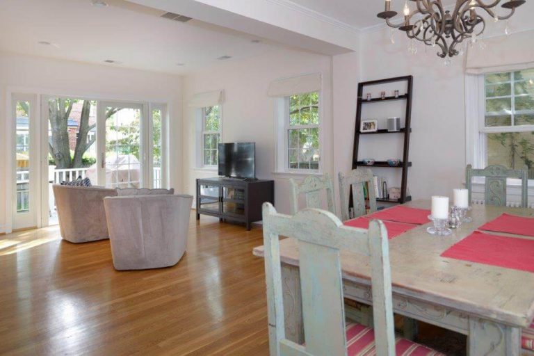 renovated living and dining area in dc home farmhouse style soft pink color palette wood floors and large windows
