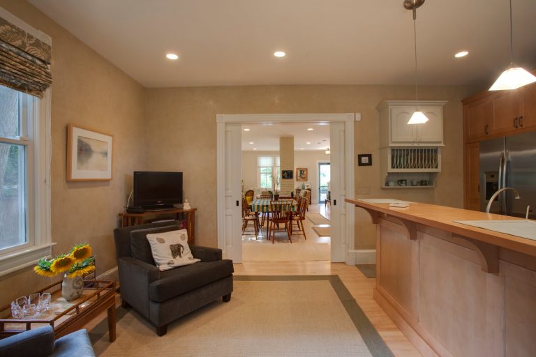 renovated farmhouse style kitchen opens up to living and dining rooms bar height island pendant lighting