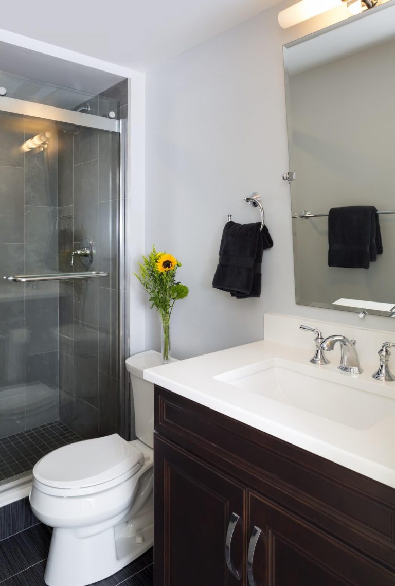 modern bathroom with black tile and dark wood vanity