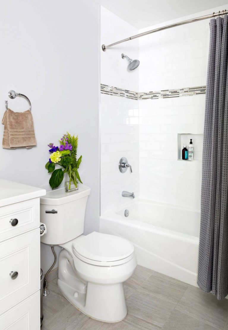 farmhouse style bathroom tub and shower with built in storage nook and tile detail