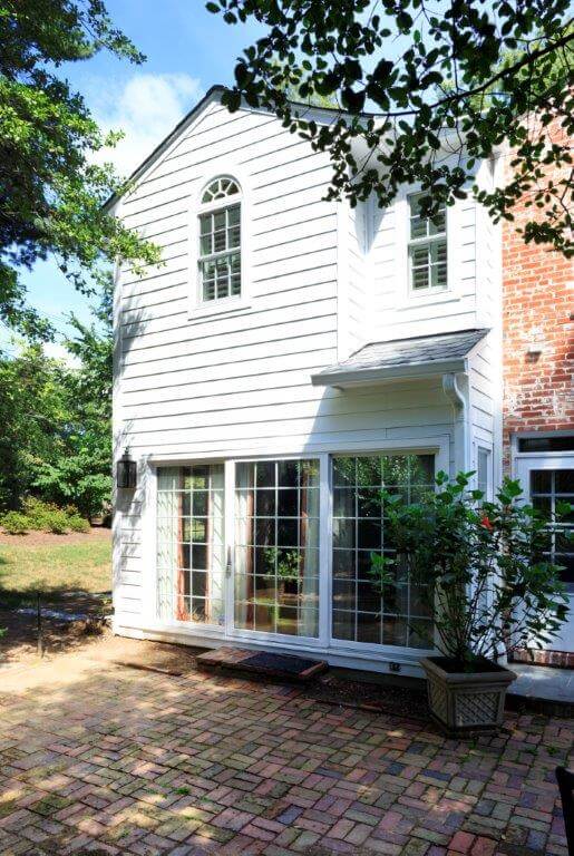 large addition on traditional style brick maryland home large sliding glass doors lead out to patio