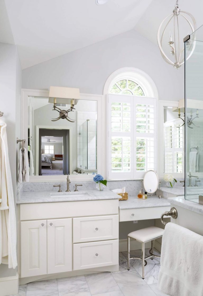 bright white master bathroom double sinks and built in vanity high ceiling and large window