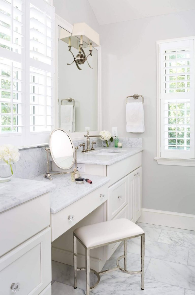 bright white master bathroom double sinks and built in vanity high ceiling and large window
