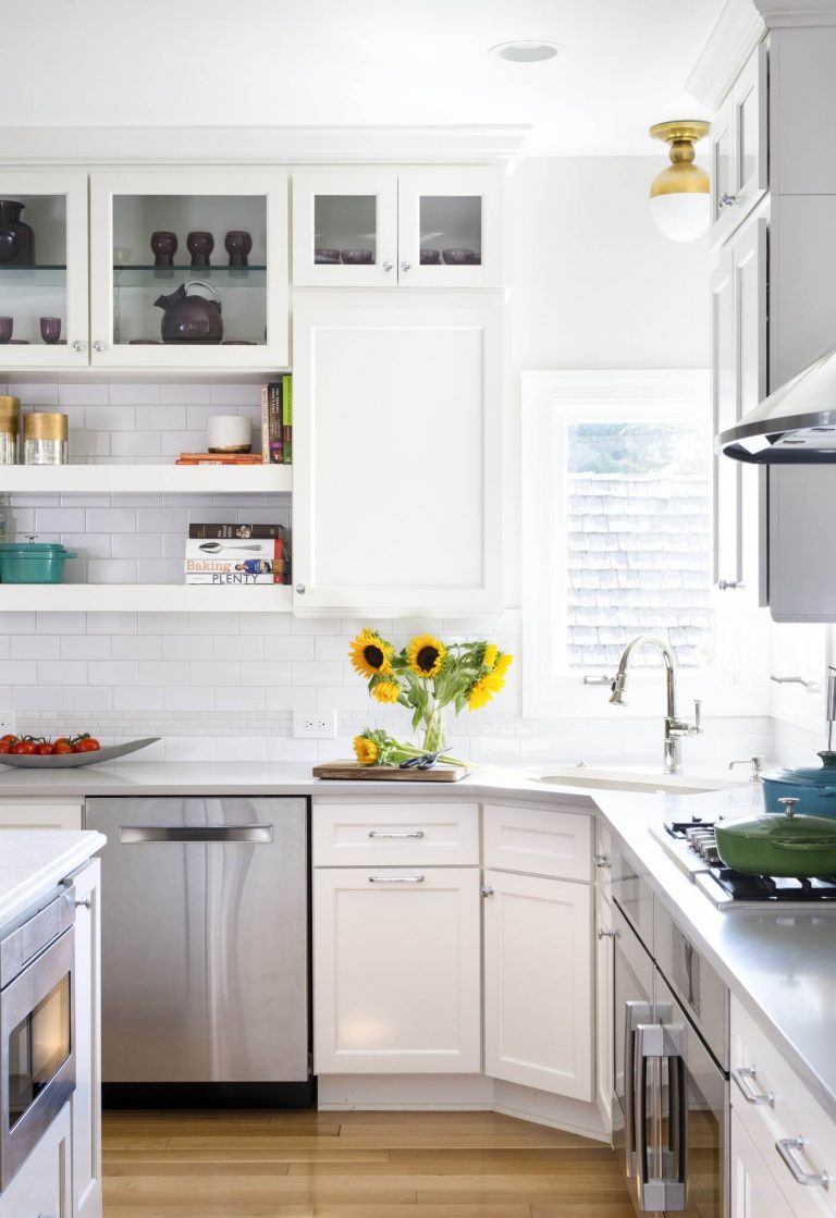 beige kitchen with glass door upper cabinetry and open shelving center island with seating and pendant lighting