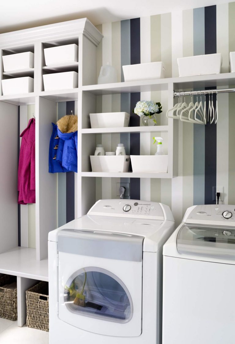 laundry area in mudroom striped wallpaper green and neutral color tones built in hooks and cubbies