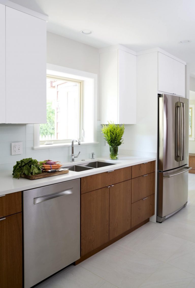 natural wood lower cabinetry white upper cabinetry stainless steel appliances window over sink