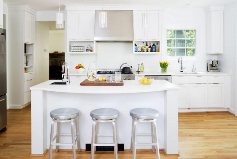 sleek and bright white farmhouse kitchen seating at island wood floors stainless steel appliances and range hood