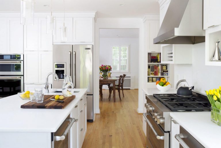 bright white farmhouse kitchen with natural color wood floors stainless steel appliances gas range and hood