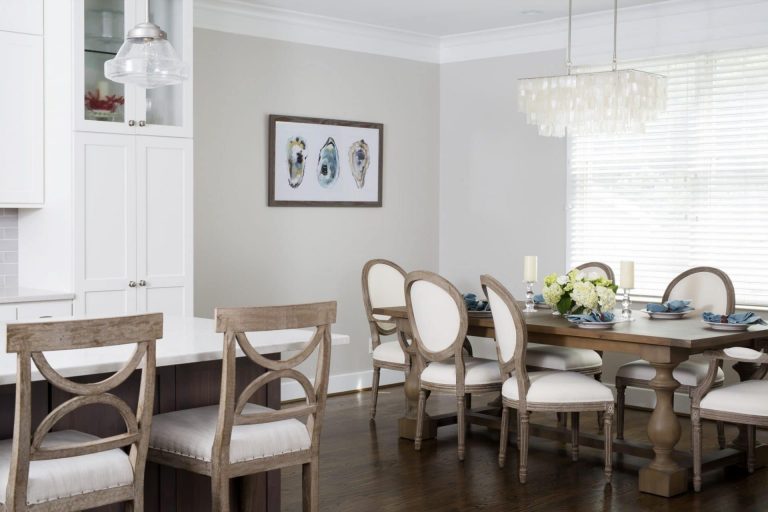 dining area off of kitchen neutral color palette large window chandelier