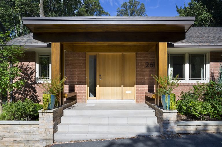 modern brick home new front porch with wood columns and overhang stone foundation mixed materials