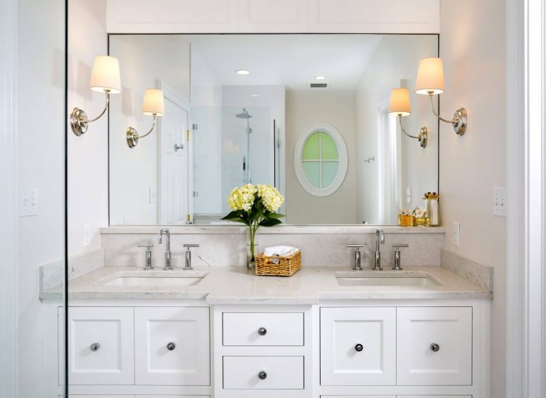 bathroom beige color palette double sink vanity with white cabinetry and sconce lighting
