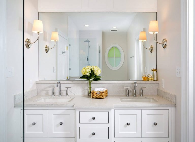 bathroom beige color palette double sink vanity with white cabinetry and sconce lighting