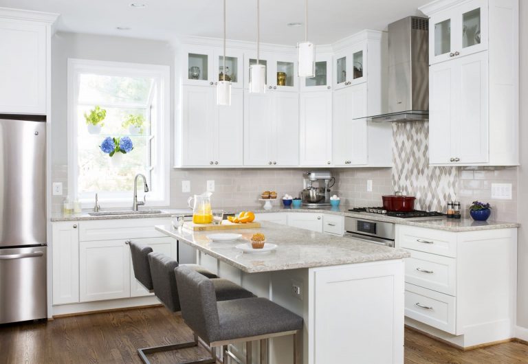 farmhouse style kitchen white cabinetry glass door uppers center island mosaic backsplash detail behind stainless steel range and hood