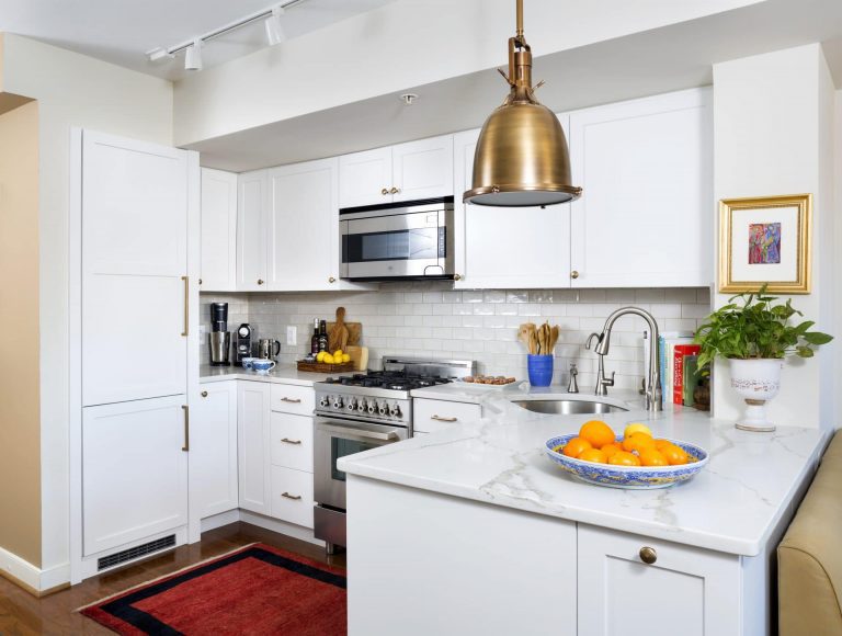 bright white kitchen with gold accents and pendant lighting wood floors