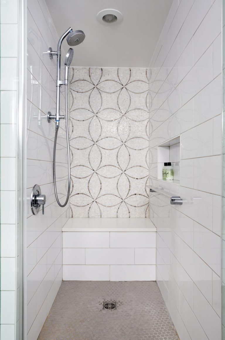 light gray bathroom glass shower stall with mosaic tile feature bench and grab bar