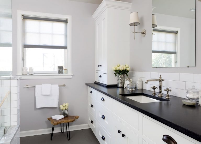 black and white bathroom with plenty of storage subway tile backsplash sconce lighting