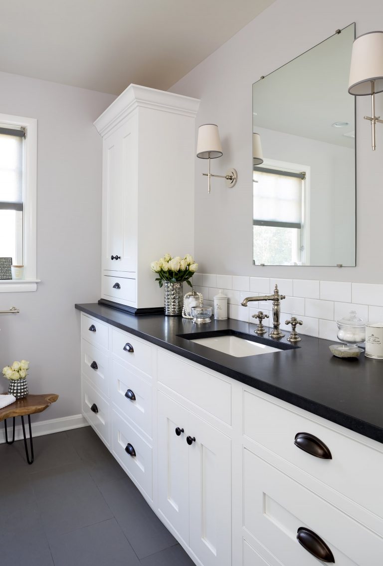black and white bathroom with plenty of storage subway tile backsplash sconce lighting