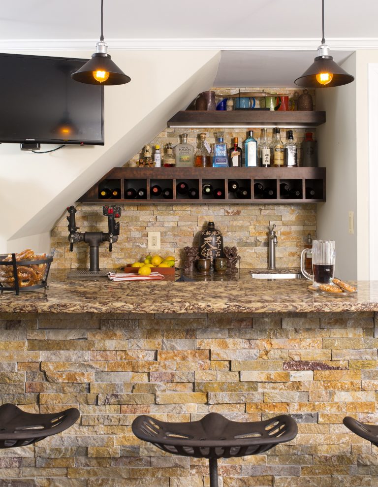 home basement bar stone detail and backsplash warm color tones wall mounted flat screen tv pendant lighting open shelving and storage