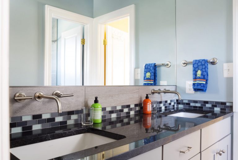 sleek updated bathroom tile backsplash and wall mounted faucets blue color palette