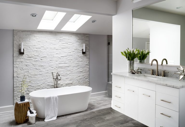 modern bathroom freestanding tub tile floors look like wood textured stone feature wall skylight gray color palette
