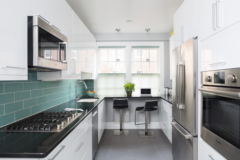 modern kitchen white cabinetry black countertops teal subway tile backsplash