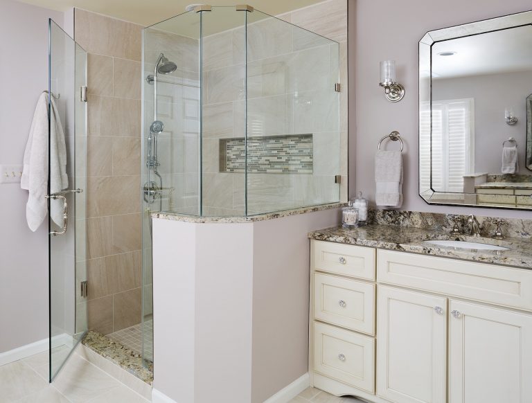 elegant master bathroom neutral pink color palette separate shower stall with glass door and built in storage nook