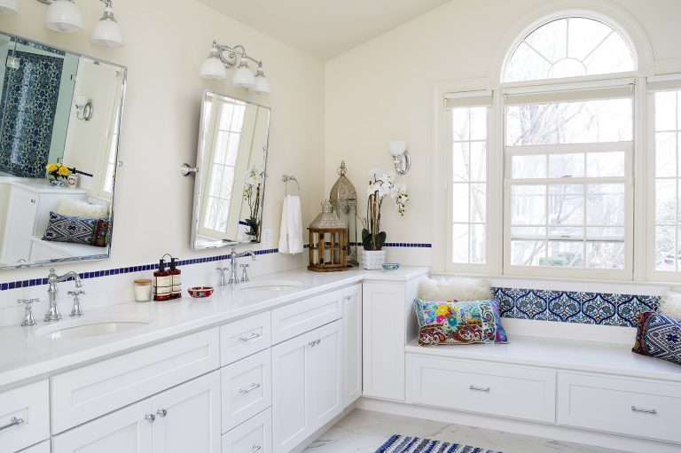 bright renovated bathroom with white cabinetry double sink vanity bay window with built in seat
