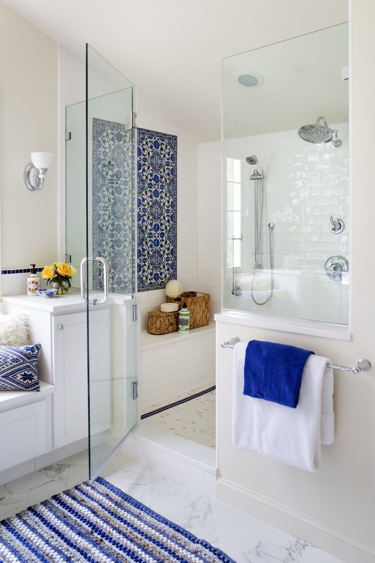 separate shower stall with half wall and glass door built in bench and blue mosaic tile feature