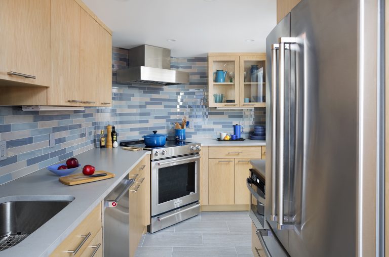 modern dc kitchen light wood cabinetry upper cabinets with glass doors blue tile backsplash stainless steel appliances