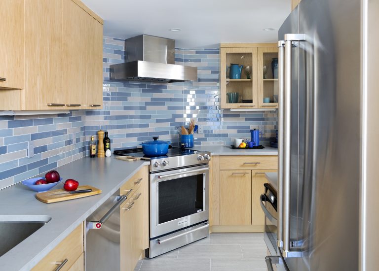 modern dc kitchen light wood cabinetry upper cabinets with glass doors blue tile backsplash stainless steel appliances